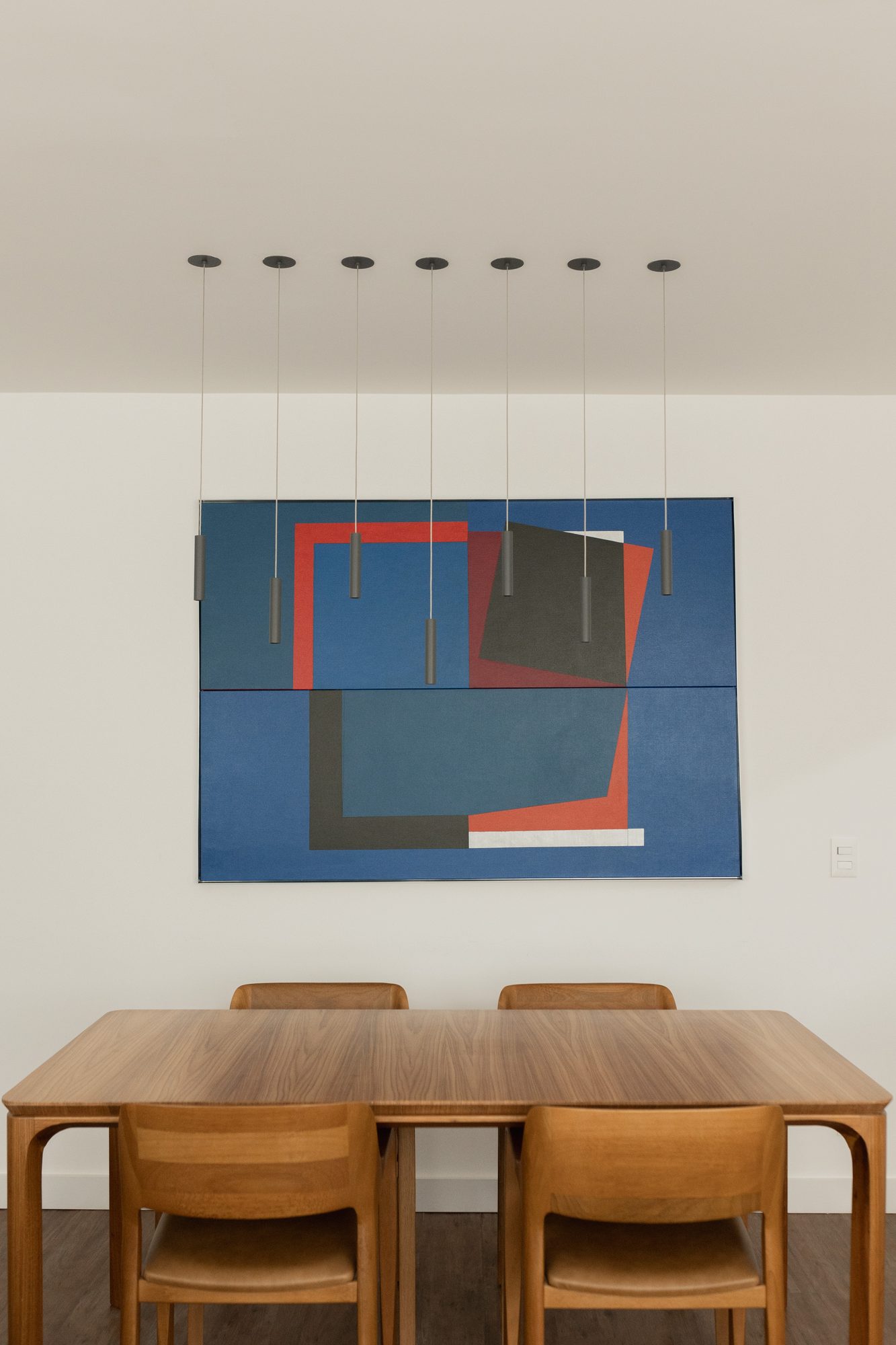 Mesa de jantar com quadro azul e pendentes