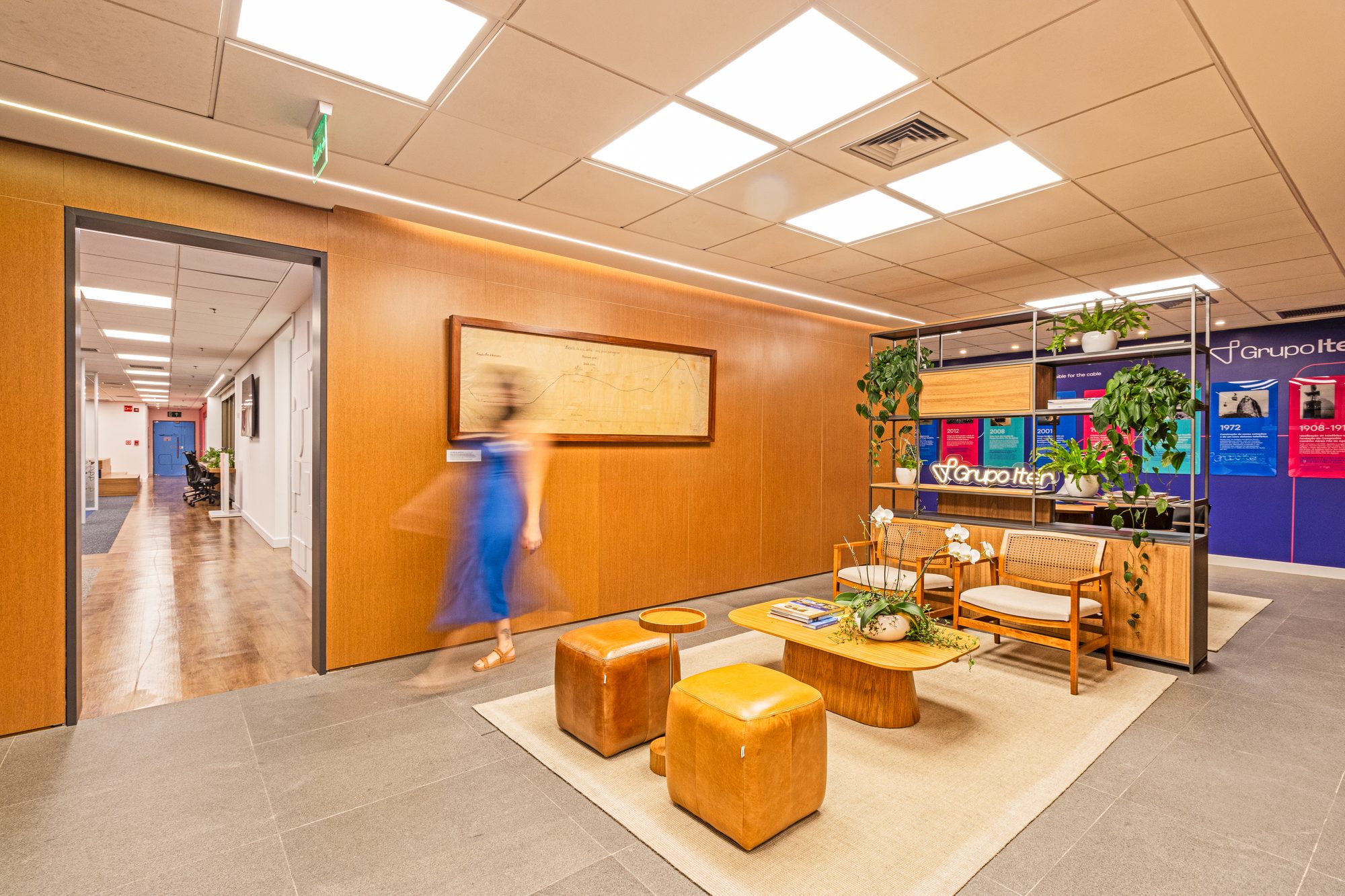 Lounge com pufes laranja, marcenaria e plantas