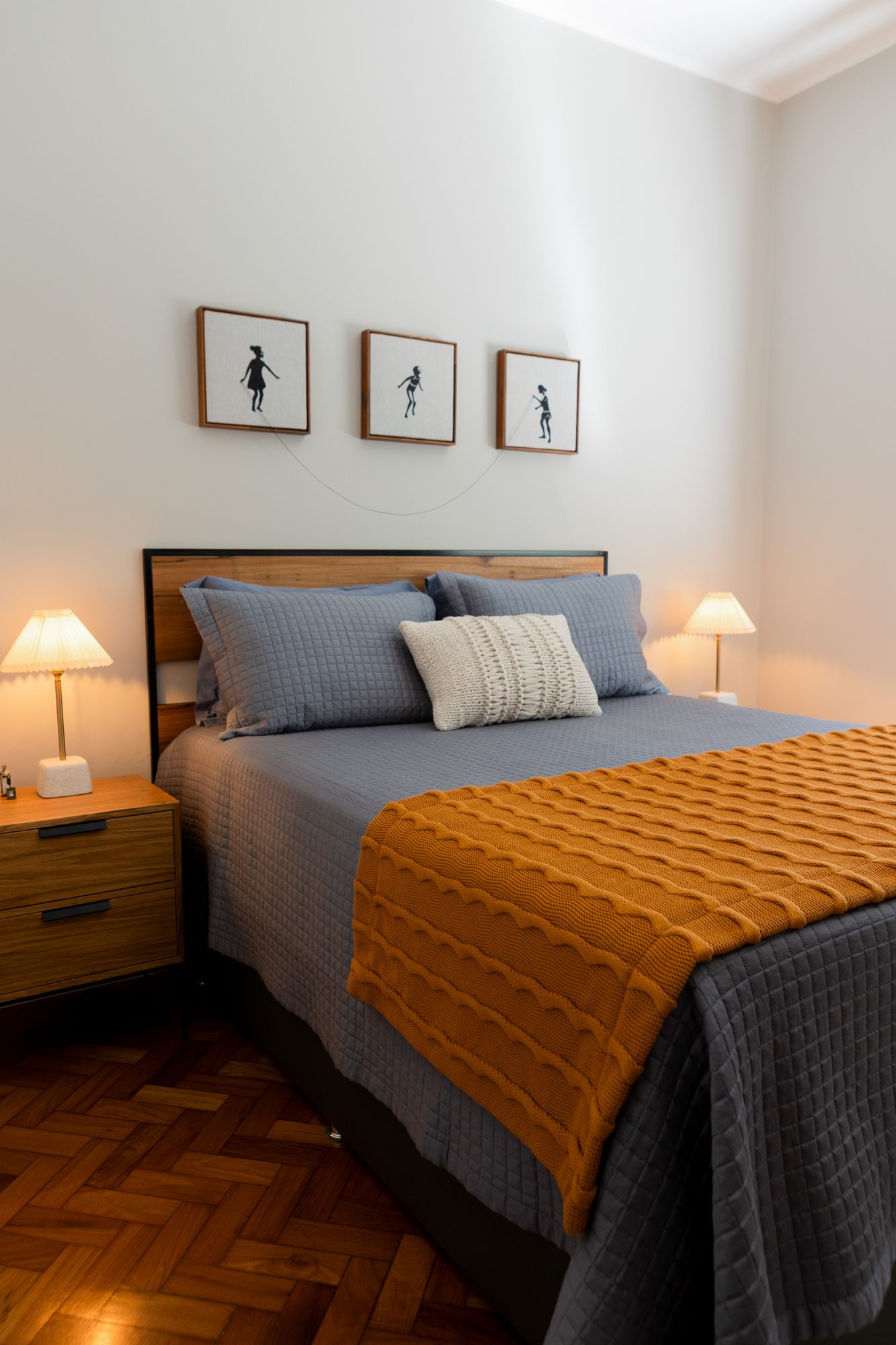 Quarto de casal com manta mostarda e roupa de cama azul