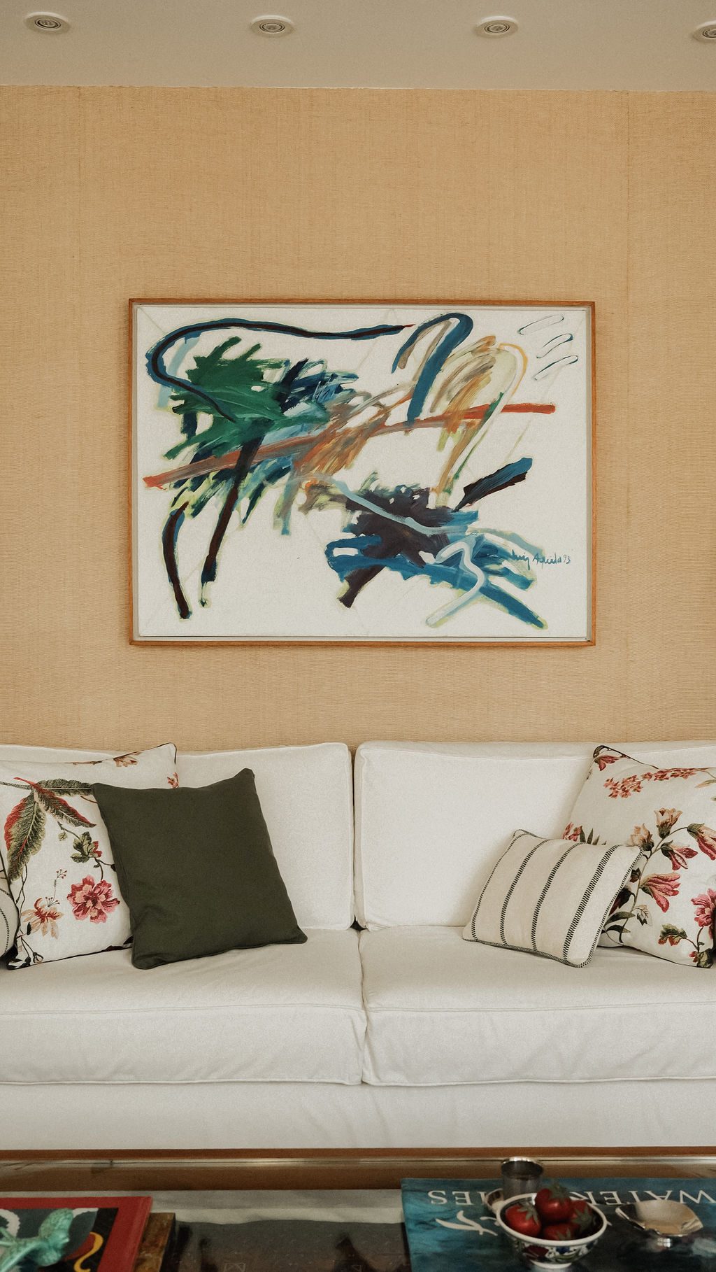 Sofá branco com almofadas e pintura abstrata