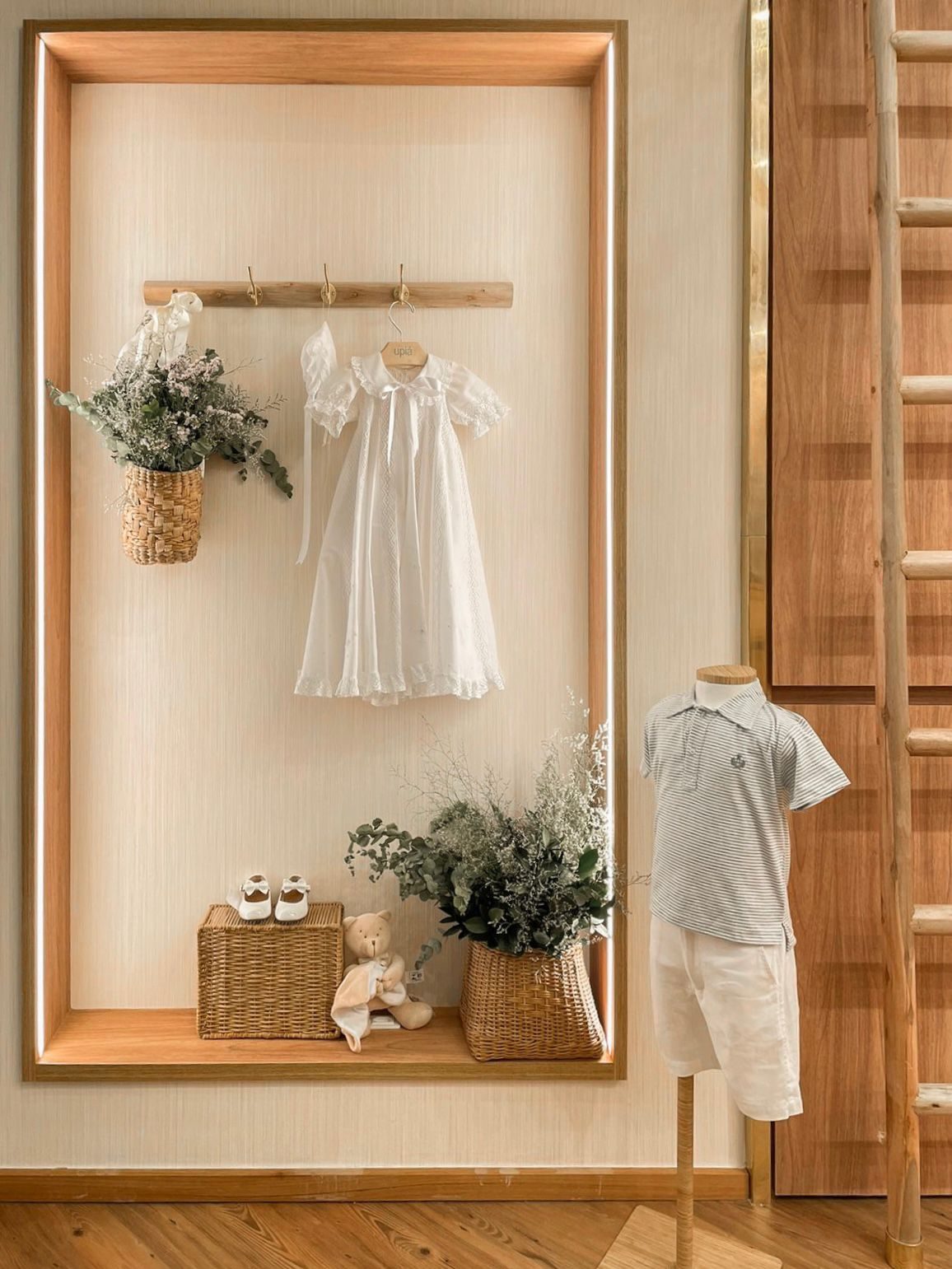Vitrine em nicho iluminado com vestido branco e cesto de palha