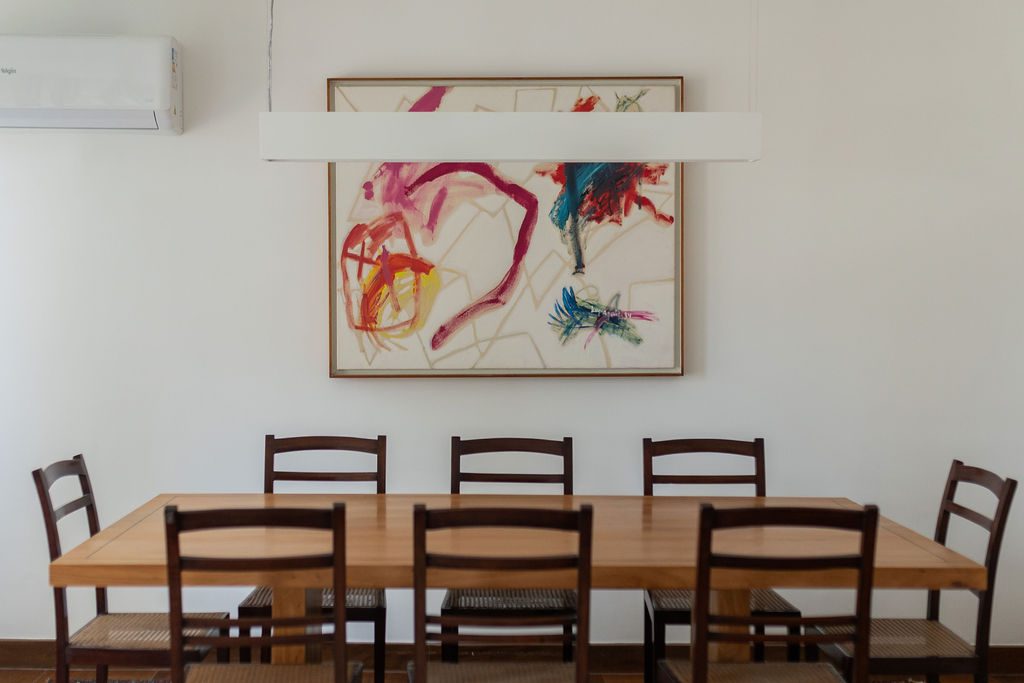 Mesa de jantar com quadro abstrato ao fundo