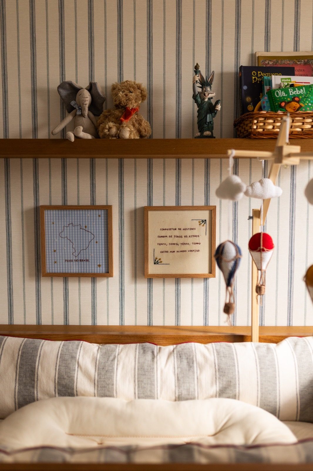 Prateleira com brinquedos e quadros sobre o sofá do quarto