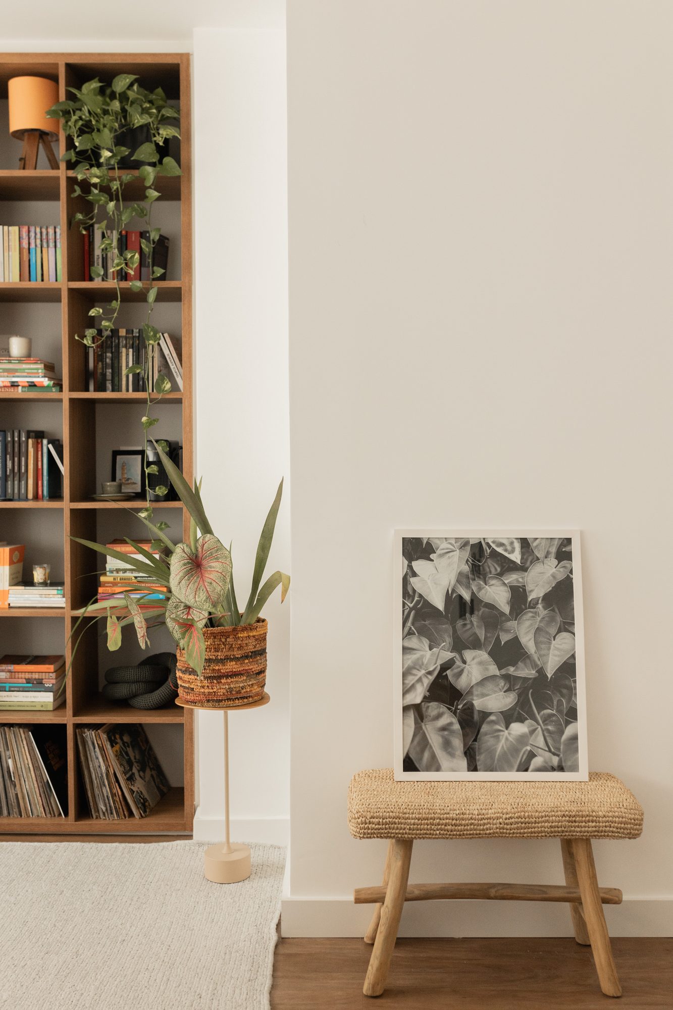Estante de livros com banco de madeira e quadro