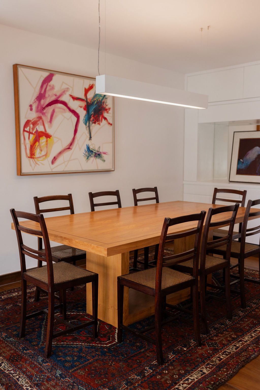 Sala de jantar com mesa de madeira e cadeiras escuras