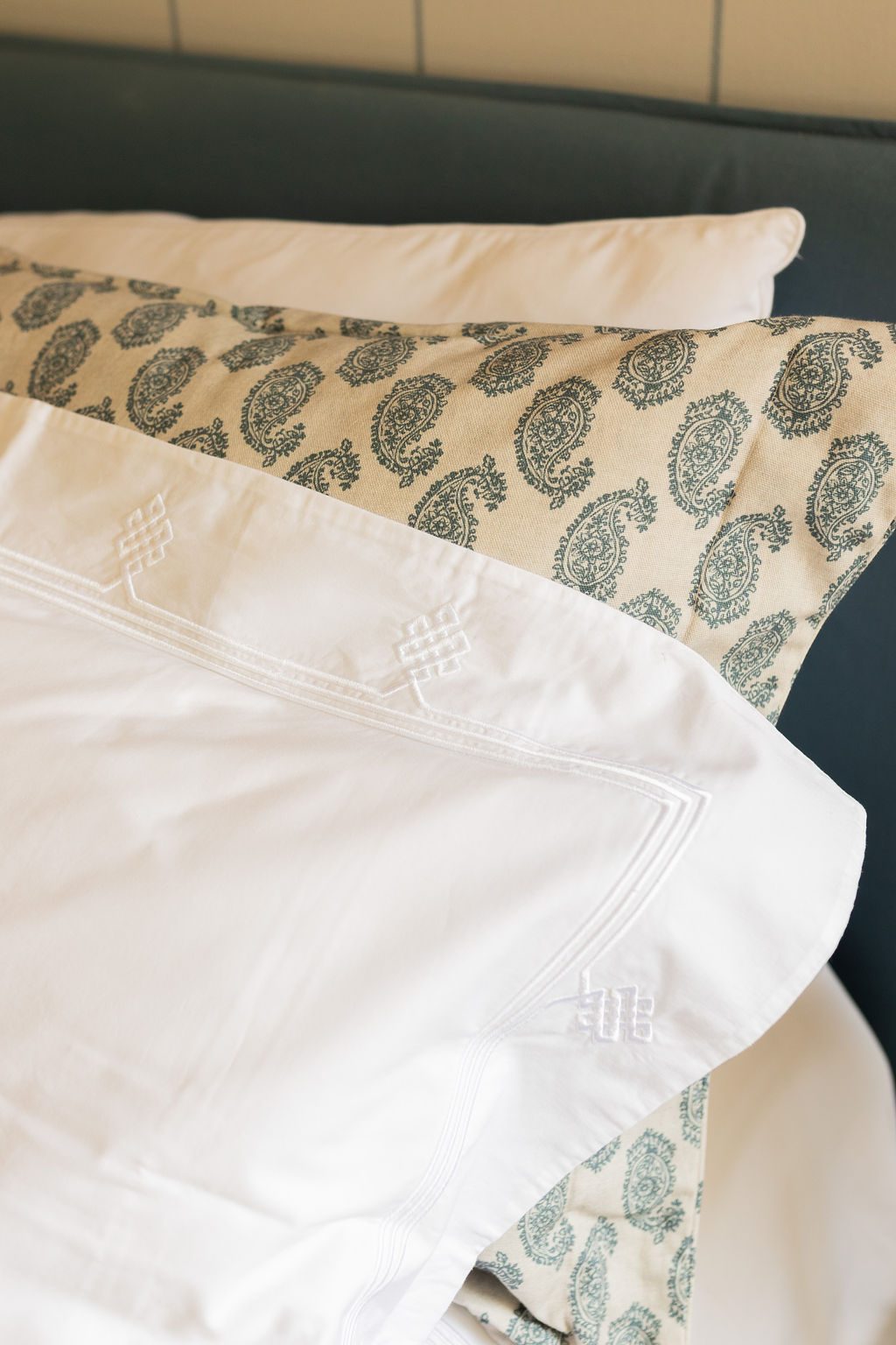 Detalhe da roupa de cama branca com almofada estampada