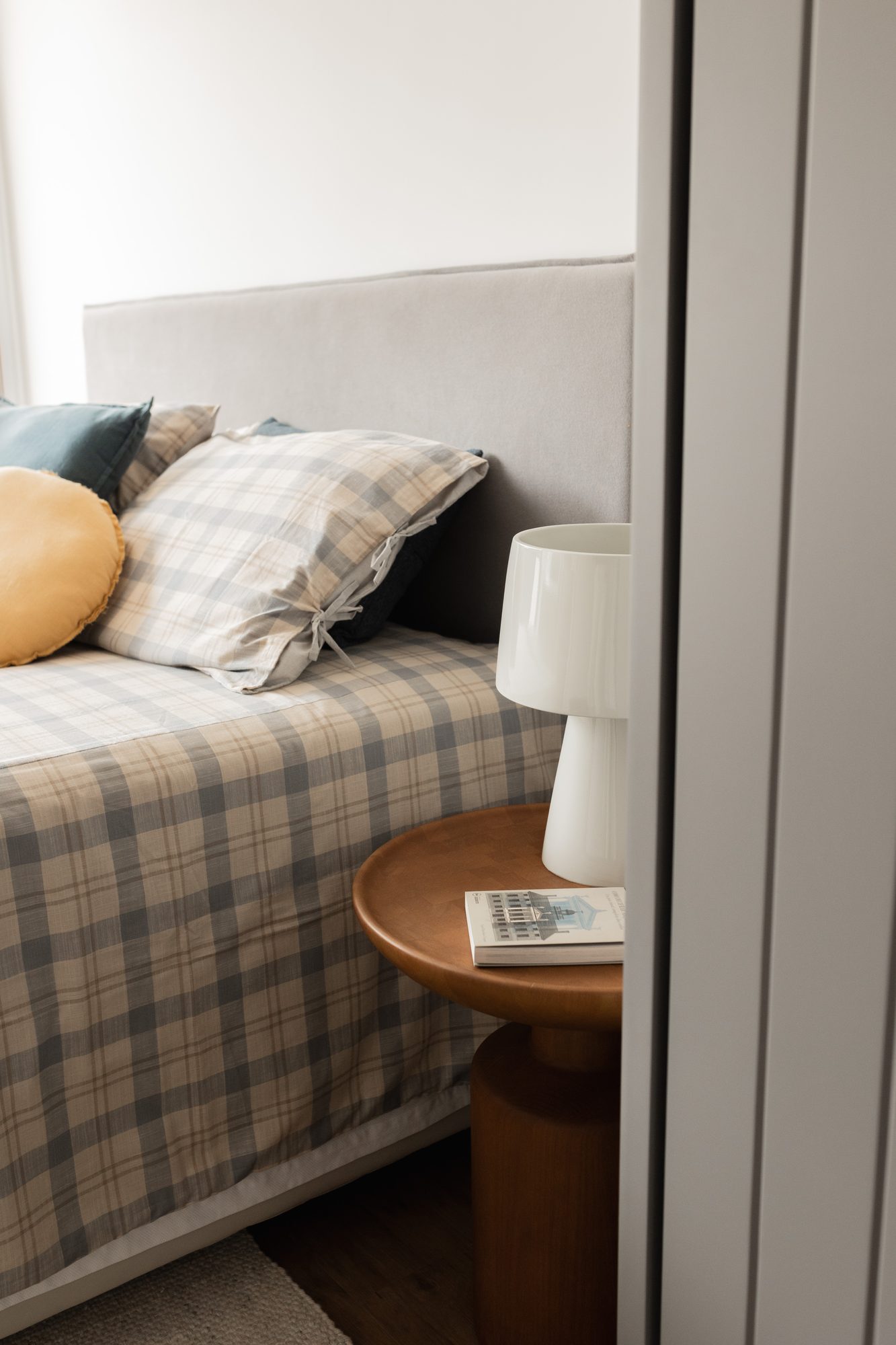Cama de casal com manta xadrez e abajur