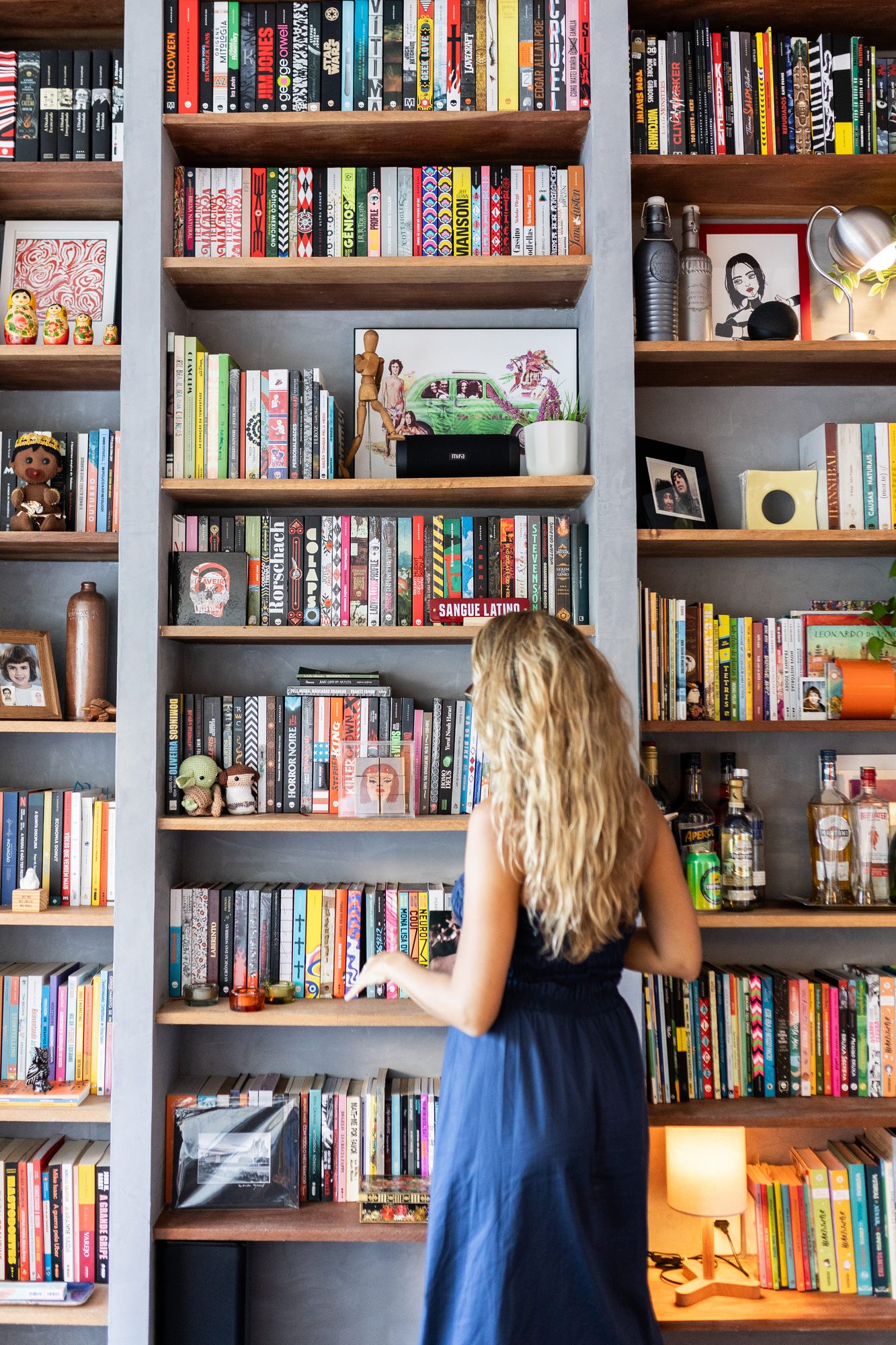 Moradora diante da estante de livros