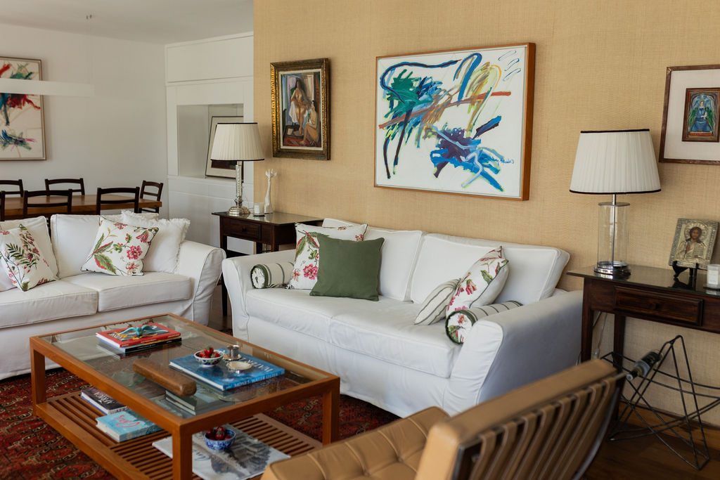 Sala de estar com sofás brancos, pintura e abajures